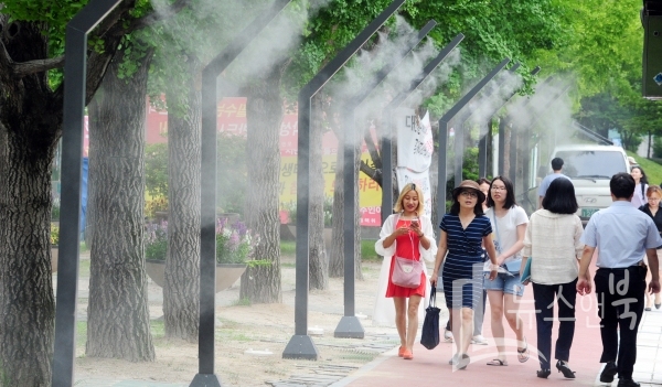 무더운 날씨를 보인 17일 대전시청 북문 앞에 설치된 쿨링포그(Cooling fog) 아래로 시민들이 지나가며 열기를 식히고 있다. 인공 안개비 시설인 쿨링포그(Cooling fog)는 노즐을 통해 물을 안개처럼 분무시켜 물방울이 증발하면서 주변 열기를 빼앗아 온도를 낮추는 시스템이다. 이선규 기자 yongdsc@newsnbook.com