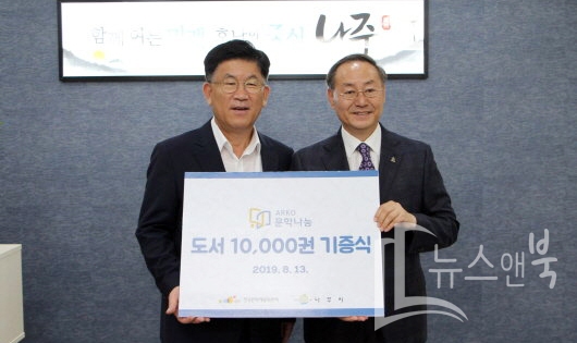 한국문화예술위원회 박종관 위원장(오른쪽)이 강인규 나주시장에게 '도서 1만 권'을 기증했다. 사진제공=나주시.