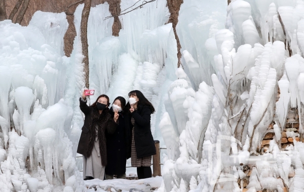 강추위가 계속된 가운데 1년중 가장 춥다는 대한(大寒)을 하루 앞둔 19일 대전 동구 상소동산림욕장에 조성된 얼음동산에서 여성들이 스마트폰으로 사진을 찍으며 추억을 담고 있다. 전우용 기자