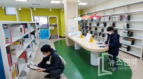 비교적 포근한 날씨를 보인 26일 대전 유성구 한 도서관에서 겨울방학을 맞은 초등학생이 아빠와 함께 마스크를 쓴 채 사회적거리를 유지한 채 책을 읽고 있다. 전우용 기자