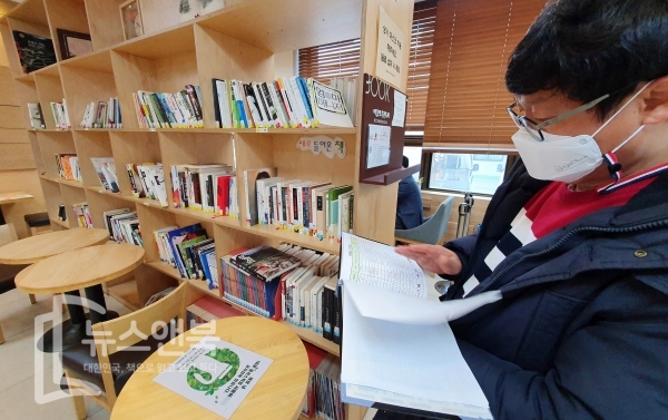 다중이용시설지역에서 사회적 거리두기 지침이 원만하게 이뤄지고 있는 가운데 8일 대전 유성구청 쉼터카페에서 마스크를 쓴 한 시민이 책을 살펴보고 있다. 전우용 기자