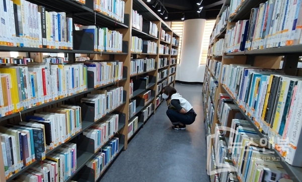 23일 대전 유성도서관에서 한 여성이 책을 고르고 있다. 전우용 기자