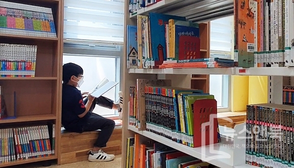 무더위속 국지성 소나기가 내린 가운데 29일 대전 서구 만년뜰작은도서관에서 마스크를 쓴 한 학생이 창가틀에 자유롭게 앉아 책을 읽고 있다.  전우용 기자