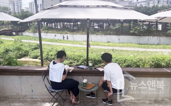 7일 대전 유성구 궁동 한 카페에서 한 커플이 자연의 풍경을 벗삼아 책읽기 데이트를 하고 있다. 전우용 기자
