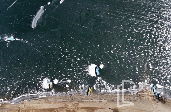 전국적으로 영하10도를 기록하며 강추위가 이어지자 대청호 가장자리가 얼어붙었다.  14일 대청호 기슭의 어선들은 얼음에 갇혀 옴짝달싹 못한 가운데 주민들이 얼음상태를 살펴보고 있다. 전우용 기자